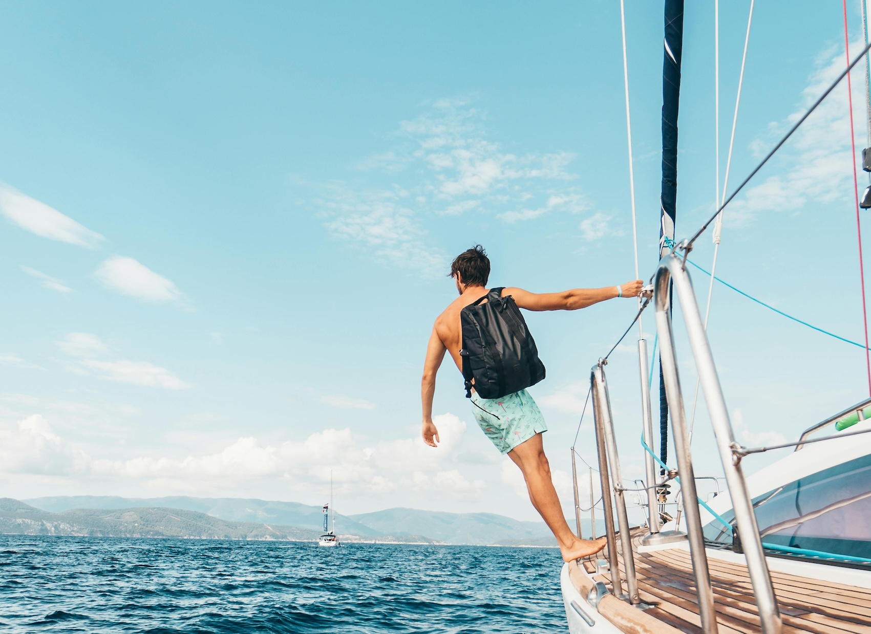 Jongen hangend aan zeilboot